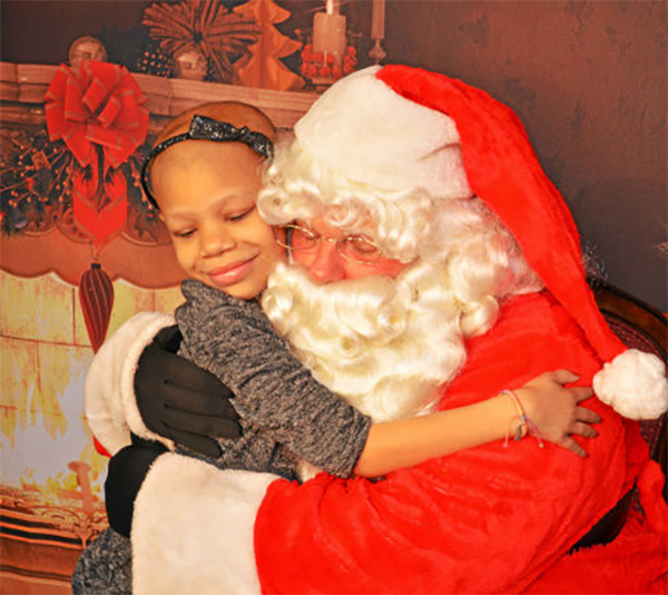Santa to the Max hugging an ill child
